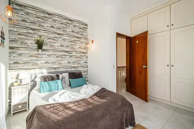 a bedroom with a bed and a brick wall at BeGuest Santa Eulália Apartment in Albufeira