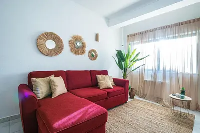 a red couch in a living room with a window at BeGuest Santa Eulália Apartment in Albufeira