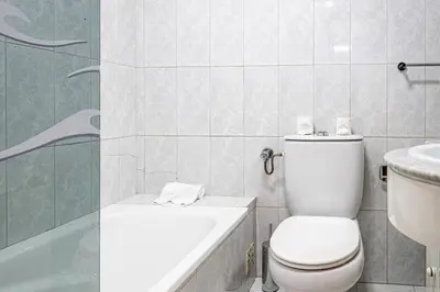a bathroom with a toilet and a tub and a sink at BeGuest Santa Eulália Apartment in Albufeira