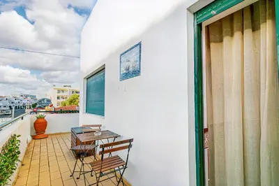 a balcony with chairs and a table on a building at BeGuest Santa Eulália Apartment in Albufeira