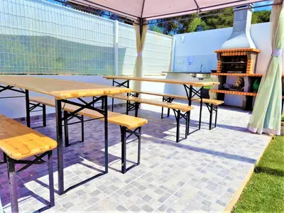 a patio with tables and chairs and a grill at O Pinhal do Avô - BY BEDZY in Almancil