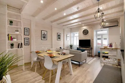a dining room and living room with a table and chairs at Casa na Travessa in Faro