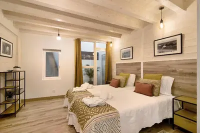 two beds in a room with wooden walls at Casa na Travessa in Faro