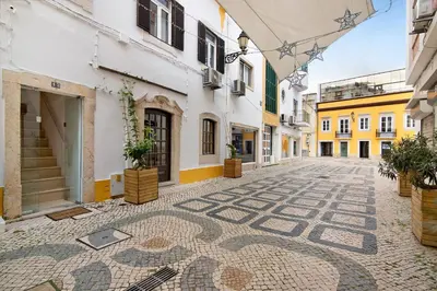 a cobblestone street in a city with buildings at Casa na Travessa in Faro