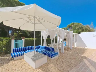 a white umbrella and lounge chairs under a table at Superb Vilamoura Villa 5 Bedrooms Villa Azul Walking Distance To Marina in Quarteira