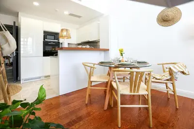 a kitchen and dining room with a table and chairs at Tropical Flavour Apartment in Faro