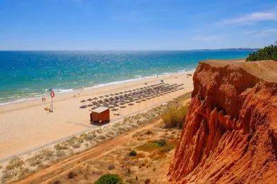 a beach with a bunch of umbrellas and the ocean at Victoria Garden in Vilamoura