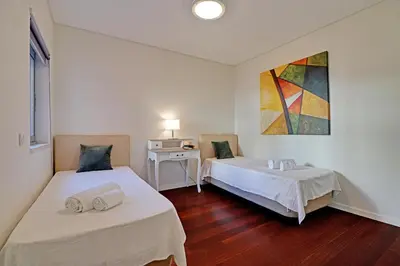 a room with two beds and a table and a painting at Victoria Secret in Vilamoura
