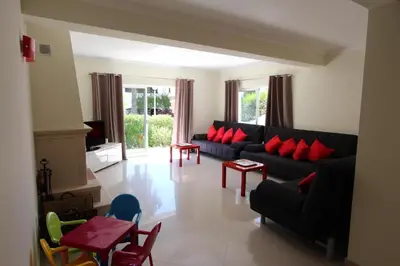 a living room with a black couch and red pillows at Modern Vilamoura Villa Close To Pinhal Golf Villa Maelou 4 Bedrooms in Quarteira