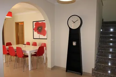 a dining room with a table and a clock on the wall at Modern Vilamoura Villa Close To Pinhal Golf Villa Maelou 4 Bedrooms in Quarteira