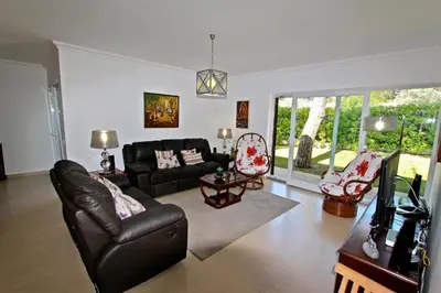 a living room with a black couch and a tv at Contemporary Portuguese Villa 4 Bedrooms Villa Violeta Private Pool in Quarteira