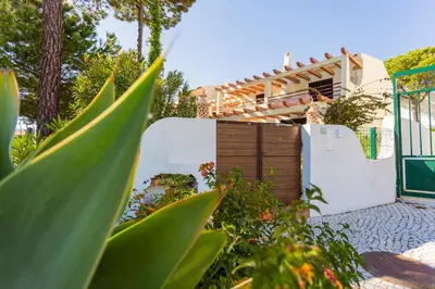 a garden with a white gate and a fence at Beach House (Golf) - Falésia/Albufeira in Albufeira