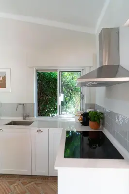 a kitchen with white cabinets and a sink and a window at Beautiful private Villa with pool, Boliqueime, Loulé in Boliqueime