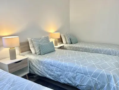 a bedroom with two beds and a couch at Oceanview - Sea front by HD PROPERTIES in Quarteira