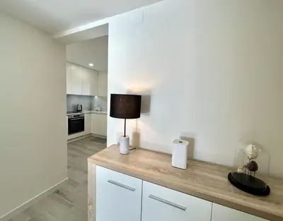 a kitchen with white cabinets and a lamp on a counter at Oceanview - Sea front by HD PROPERTIES in Quarteira