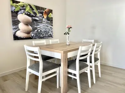a dining room table and chairs with a painting on the wall at Oceanview - Sea front by HD PROPERTIES in Quarteira