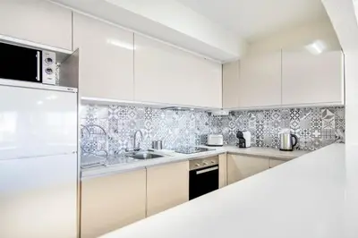 a white kitchen with white cabinets and appliances at Albufeira Holidays Near The Strip in Albufeira