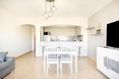 a kitchen and living room with a table and chairs at Albufeira Holidays Near The Strip in Albufeira