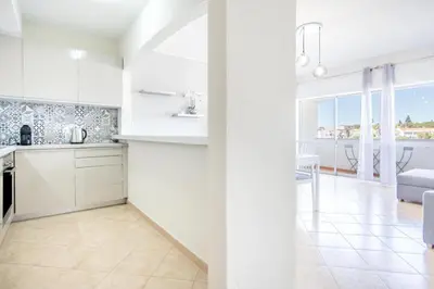 a white kitchen with a view of a living room at Albufeira Holidays Near The Strip in Albufeira