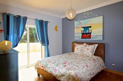 a bedroom with a bed with blue walls and a window at Luxury Vilamoura Villa 4 Bedrooms Villa Corvo Billiards in Quarteira