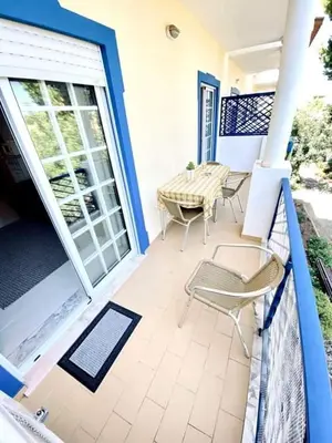a balcony with a table and chairs on a porch at Flamingos Apartment with 2 swimming pool com check in e check out ao domingo em julho e agosto in Albufeira