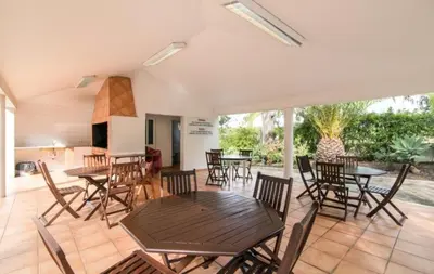 a patio with tables and chairs and a kitchen at Flamingos Apartment with 2 swimming pool com check in e check out ao domingo em julho e agosto in Albufeira