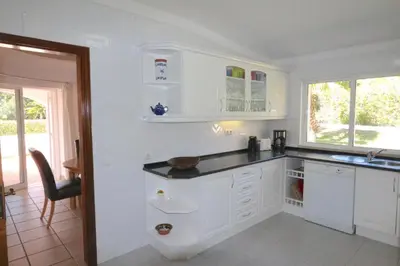 a white kitchen with white cabinets and a window at Traditional Portuguese Villa 5 Bedrooms Villa Girassol Prime Location in Quarteira