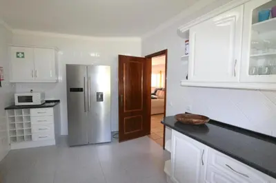 a kitchen with a stainless steel refrigerator and white cabinets at Traditional Portuguese Villa 5 Bedrooms Villa Girassol Prime Location in Quarteira