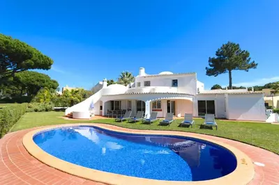 a villa with a swimming pool in front of a house at Traditional Portuguese Villa 5 Bedrooms Villa Girassol Prime Location in Quarteira