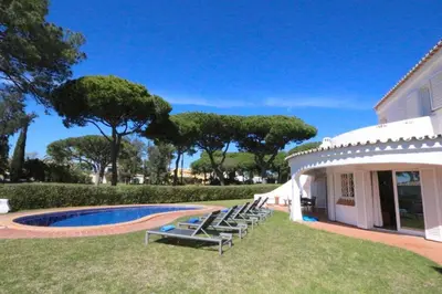 a group of chairs sitting next to a house at Traditional Portuguese Villa 5 Bedrooms Villa Girassol Prime Location in Quarteira