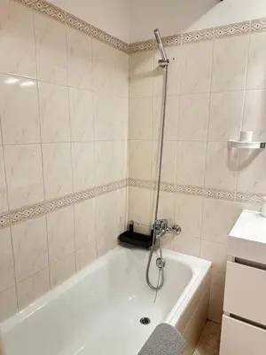 a bathroom with a bath tub and a sink at Alojamento Ramos in Quarteira