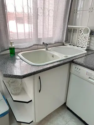 a white sink in a kitchen with a window at Alojamento Ramos in Quarteira