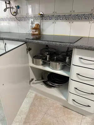 a kitchen with two pots and pans on a shelf at Alojamento Ramos in Quarteira