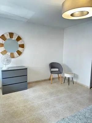 a room with a black chair and a mirror at Alojamento Ramos in Quarteira