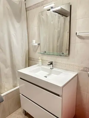 a bathroom with a white sink and a mirror at Alojamento Ramos in Quarteira