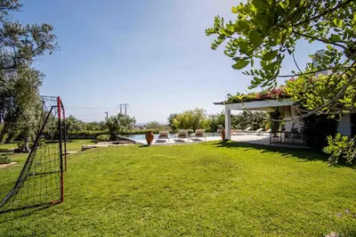 a patio with furniture and trees in a yard at Charmante villa Authentique in Loulé