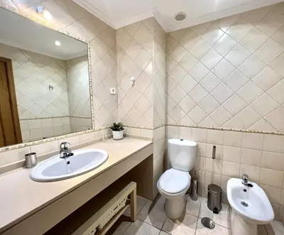 a bathroom with a toilet and a sink and a mirror at Olivos del golf - Terrace with pool by HD in Vilamoura