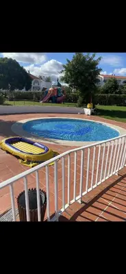 a swimming pool with a white fence and a slide at Apart 306 in Albufeira
