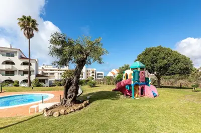 a playground in a park next to a pool at Apart 306 in Albufeira