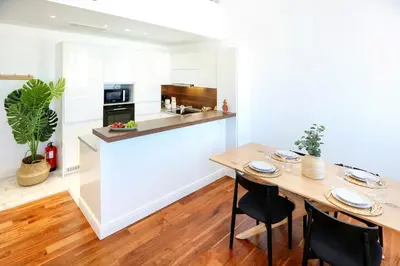 a kitchen and dining room with a wooden table and chairs at Zen & Tan Apartment in Faro