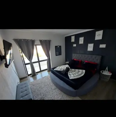 a bedroom with a bed and a large window at Albufeira SPOT com piscinas exteriores e interior! in Albufeira