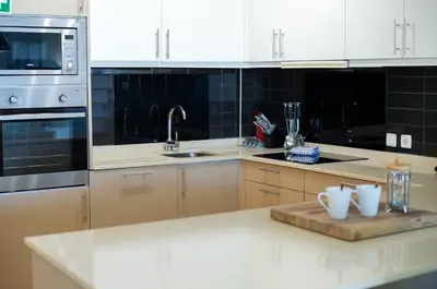 a kitchen with white appliances and a wooden cutting board at Bay View Modern Apartment in Albufeira
