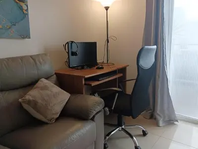 a room with a desk with a computer and a chair at Bay View Modern Apartment in Albufeira
