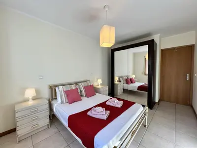 a bedroom with a large bed and a mirror at Albufeira Brightness by Homing in Albufeira