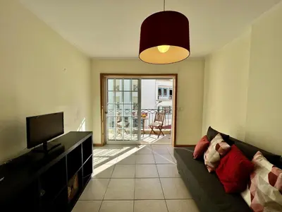 a living room with a couch and a television at Albufeira Brightness by Homing in Albufeira
