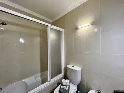a bathroom with a shower and a toilet and a tub at Albufeira Brightness by Homing in Albufeira