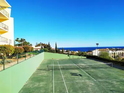 a tennis court with the ocean in the background at AlbufeiraOrada II by Be Cherish in Albufeira