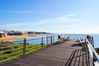 a wooden boardwalk leading to a beach with benches at AlbufeiraOrada II by Be Cherish in Albufeira