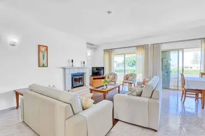 a living room with white furniture and a fireplace at Isabel Vivenda in Patroves