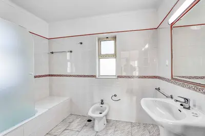 a white bathroom with a sink and a toilet at Isabel Vivenda in Patroves